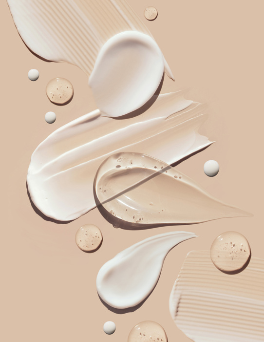 Cosmetic smears of creamy texture on a pastel beige background